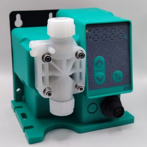 Doseco SM_Y - DOSECO Chemical Dosing Pumps Close-up of a white plastic valve connector bolted to a teal machine housing, with a digital display panel in the background.